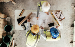 Construction crew working beside a shipping container at an active job site.